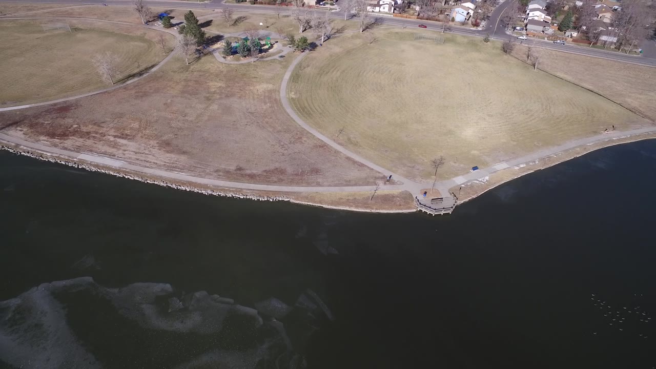 Aerial lakeshore view with a small overlook and park paths.