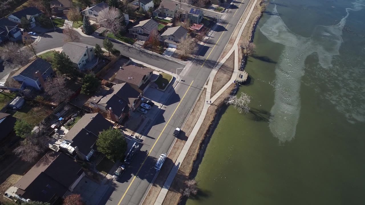 Aerial view of lakeside houses beside a two-lane road.