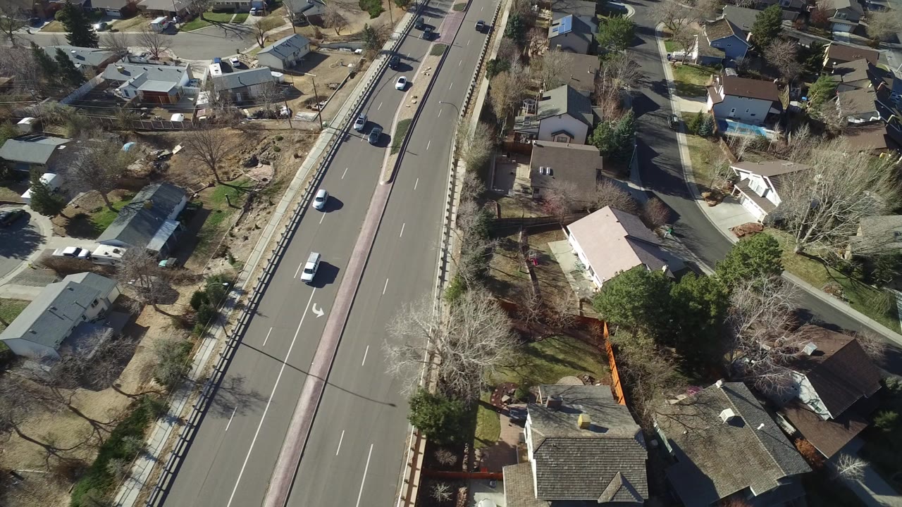Aerial view of a divided road beside suburban houses.