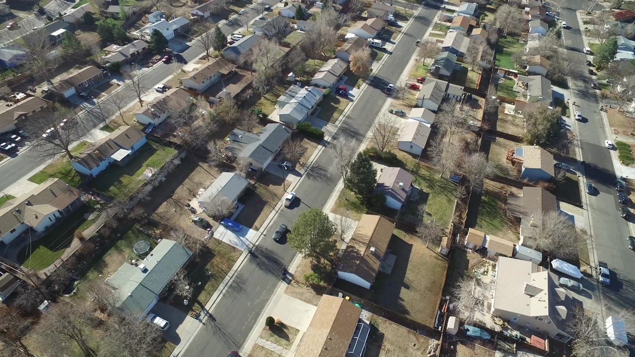 High aerial view of a neighborhood intersection and surrounding homes.