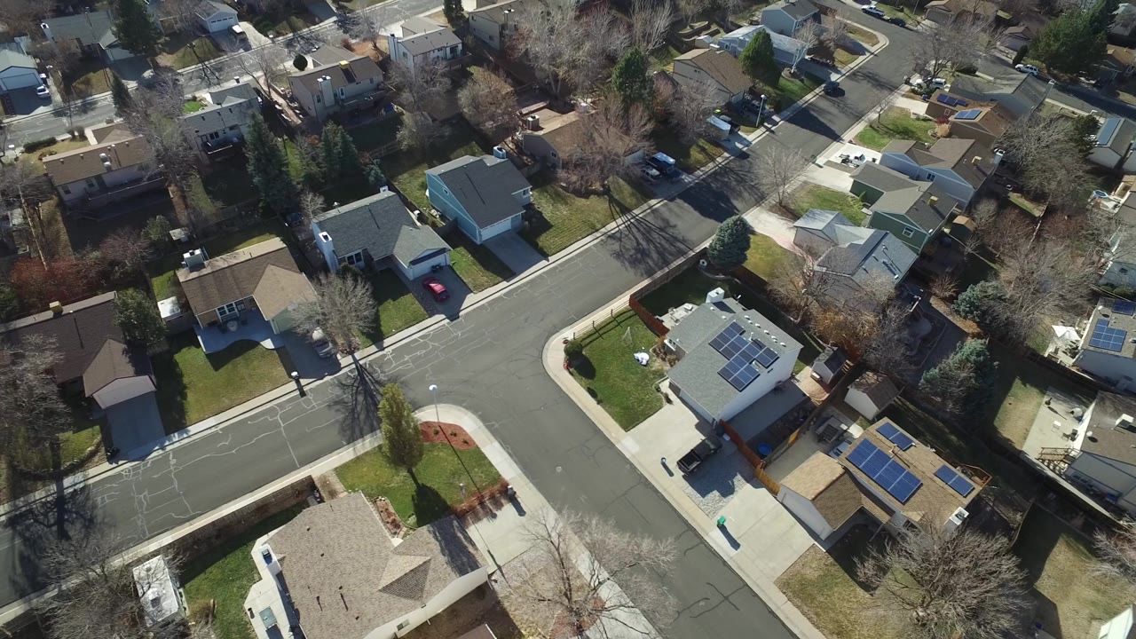 Top-down neighborhood view with houses, streets, and winter trees.
