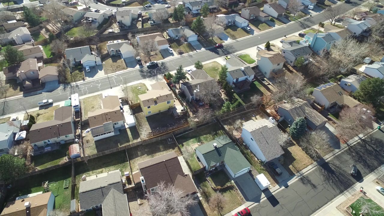 Overhead Hidden Lake, Colorado residential view with a diagonal road, compact homes, leafless trees, parked cars, and no clearly visible people.