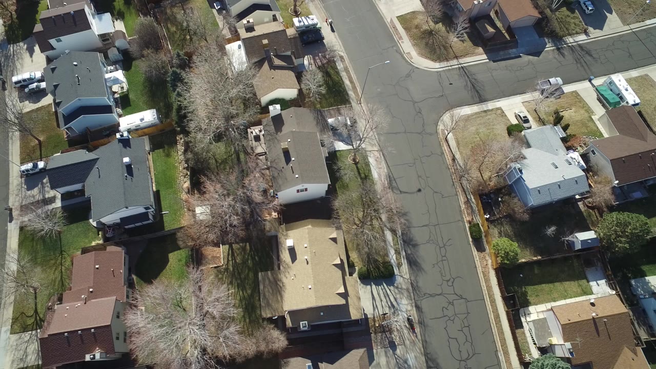 Overhead view of suburban houses and curved residential streets.