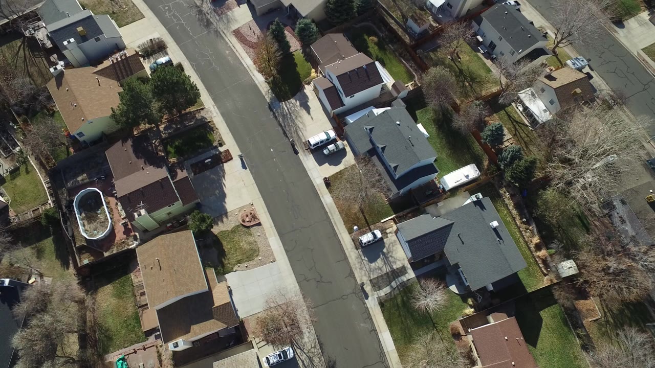 Overhead frame of Hidden Lake, Colorado homes, driveways, fenced yards, leafless trees, and a curved street with no visible people.