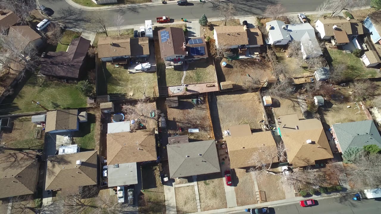 Overhead drone view of suburban homes and a residential street.