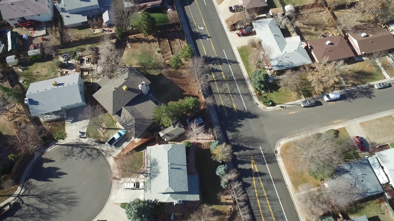 Aerial view of a residential cul-de-sac and nearby two-lane road.