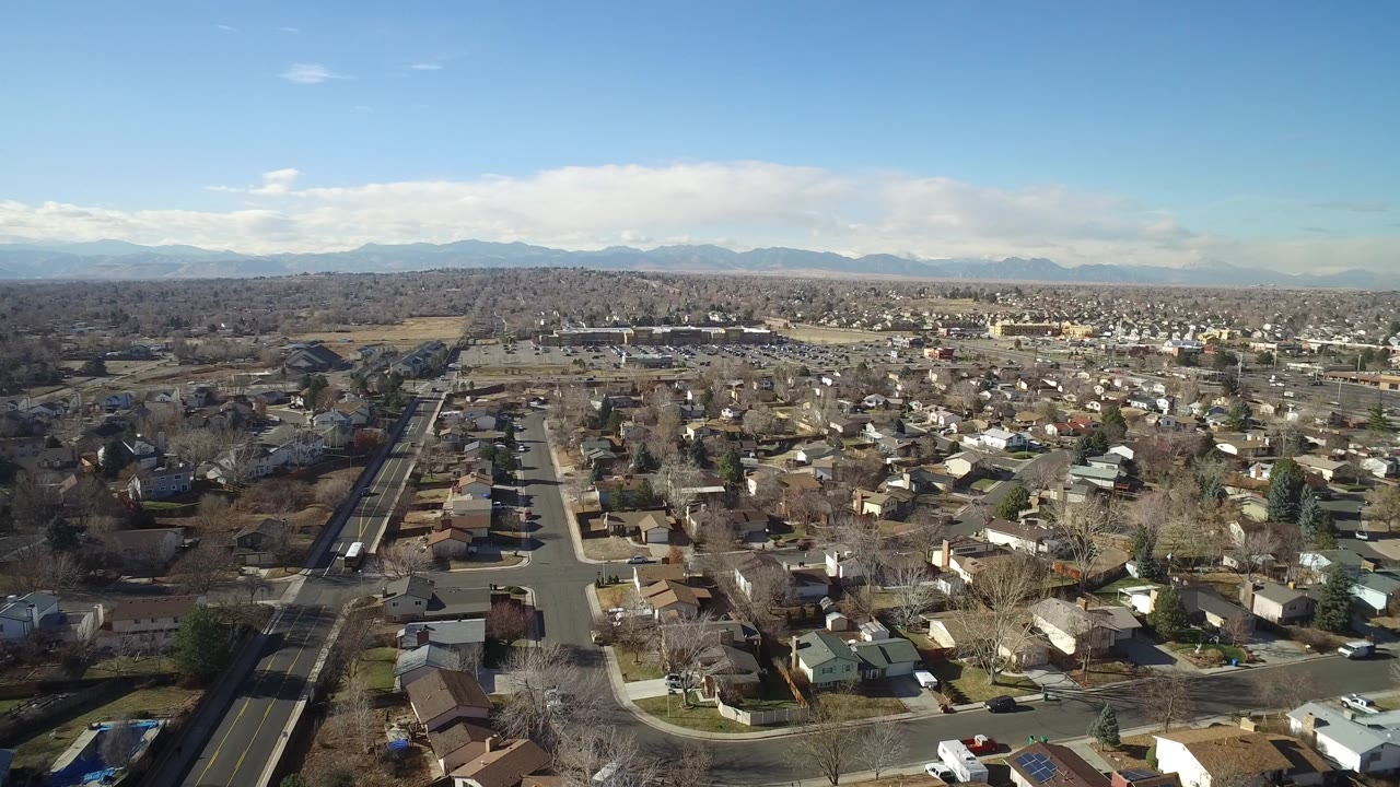 Aerial view over a dense residential neighborhood and distant mountains