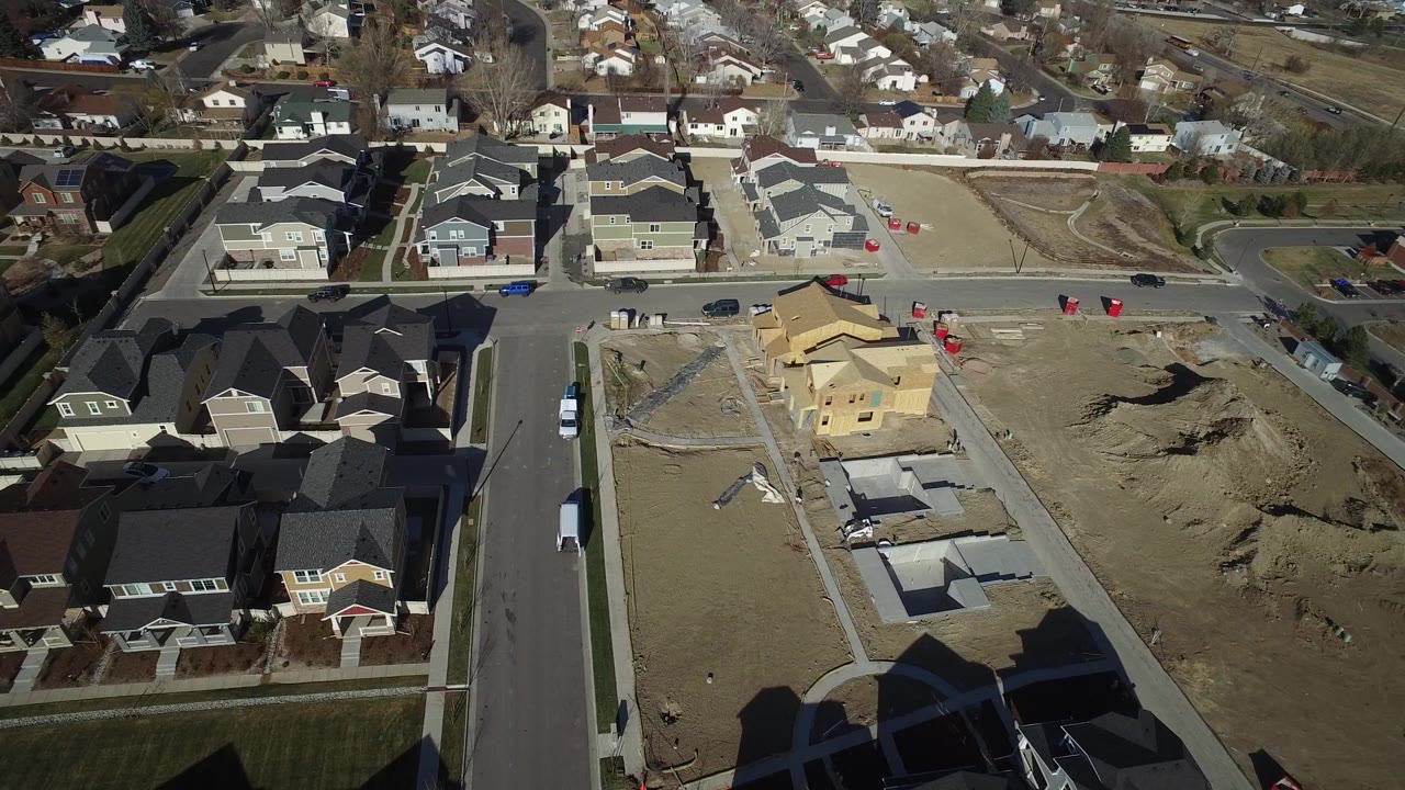 Aerial view of suburban houses and active construction lots.