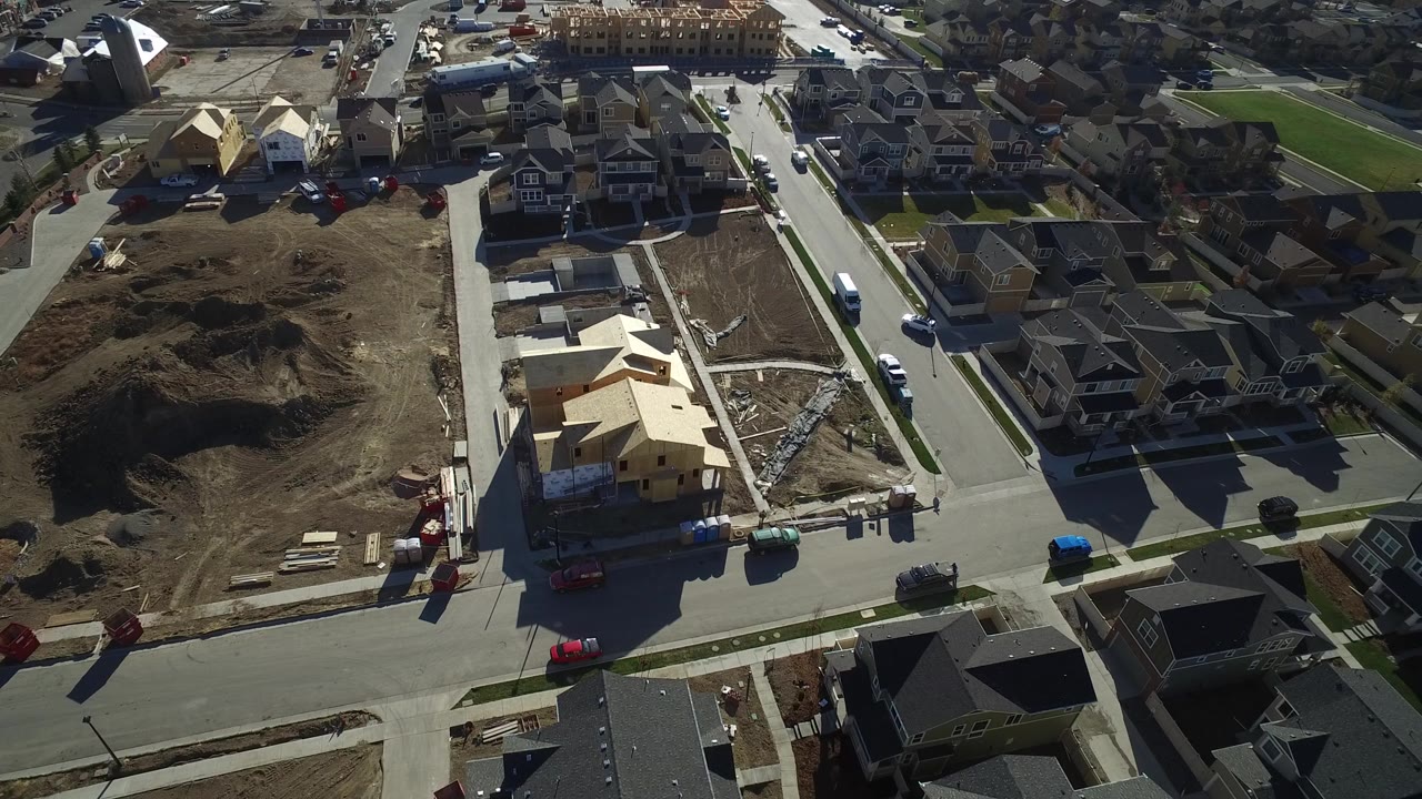 Aerial view of large homes, paved streets, and construction lots