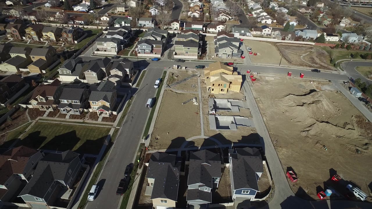 Aerial view of houses beside graded construction lots