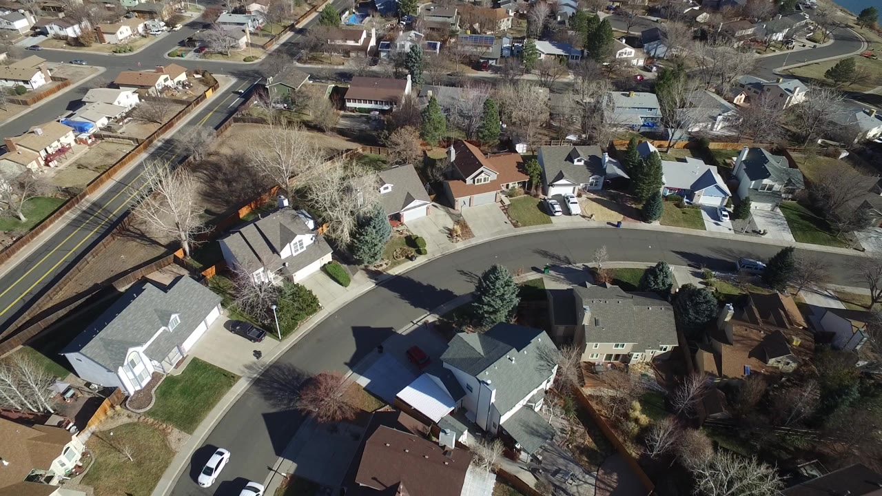 Aerial view over curved suburban streets and detached houses.