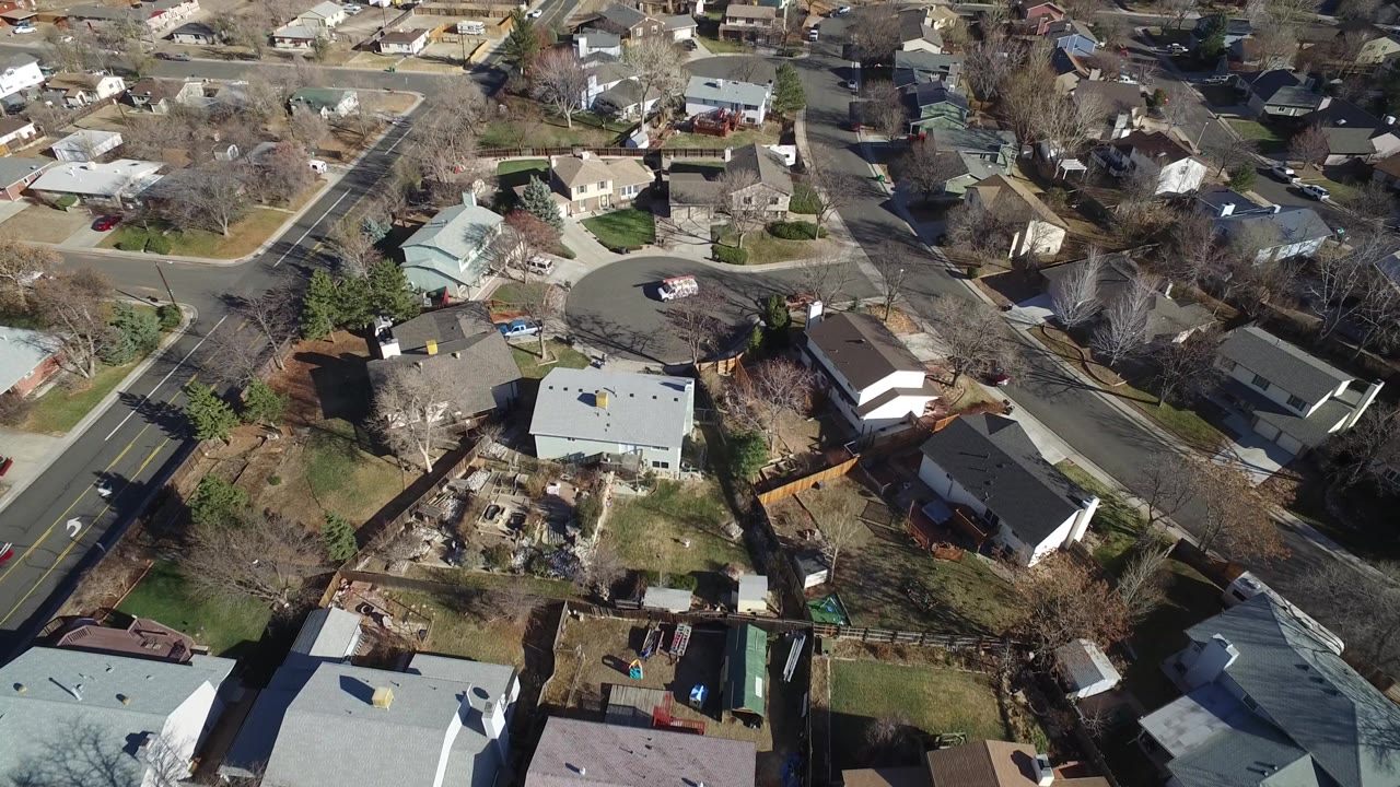 Aerial view over suburban houses and neighborhood streets.