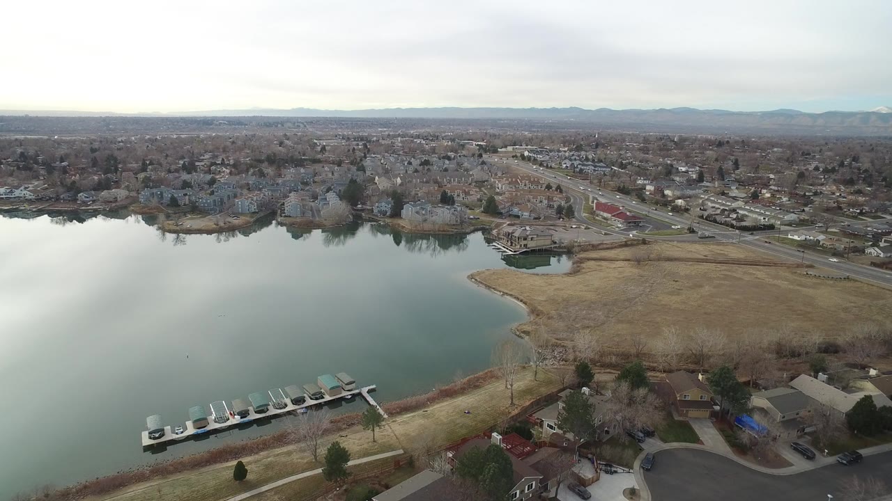 Aerial view of a lake beside suburban homes and roads