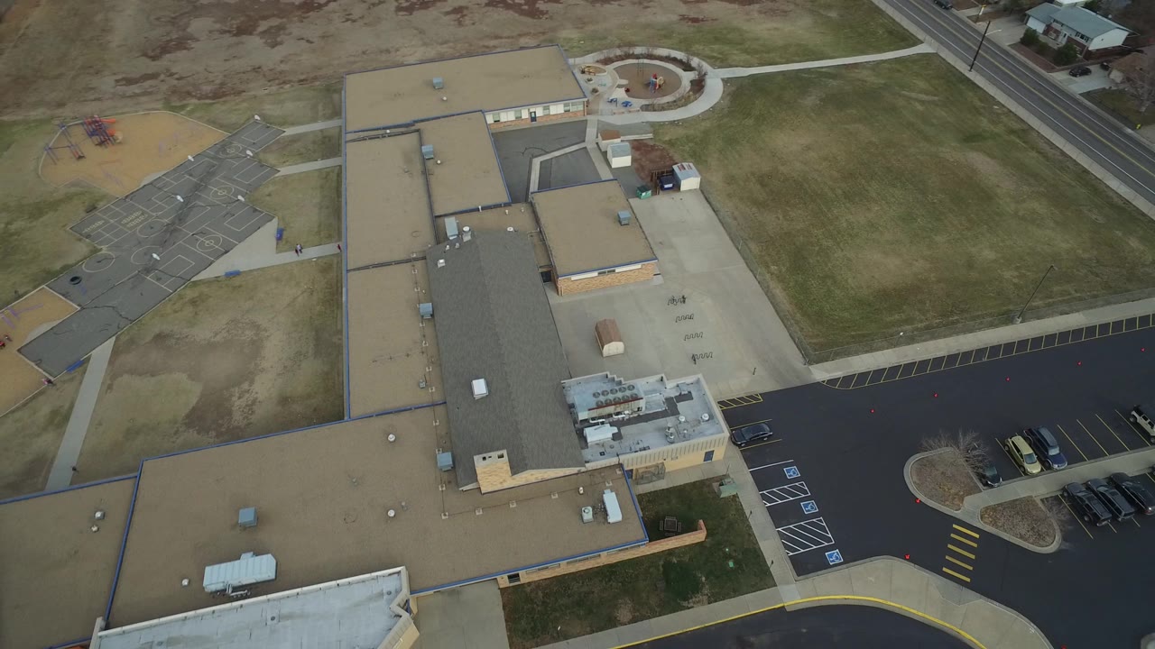 Overhead angle with a playground and paved paths near the building.