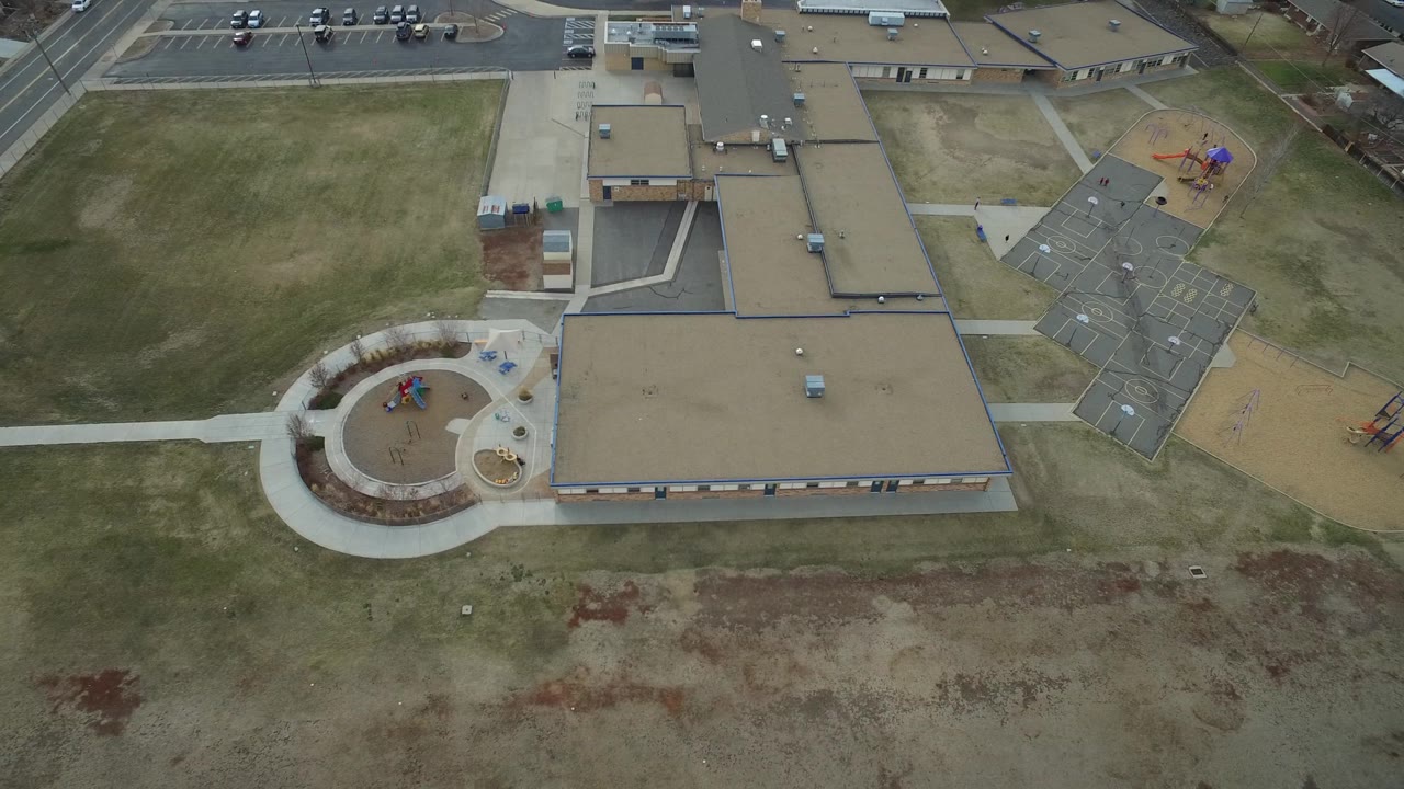 Overhead Westminster, Colorado frame with the main roof centered to the right, circular play area below it, playground equipment near the upper right, and no visible people.