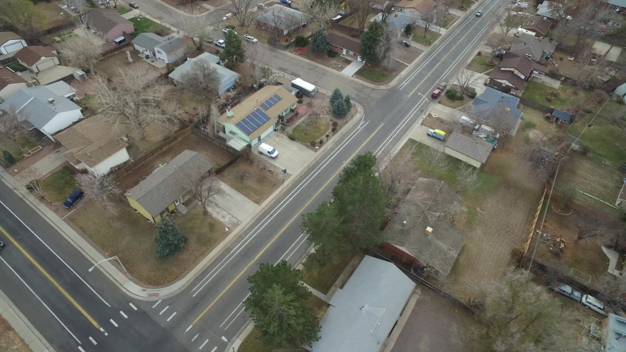 Aerial view of a suburban road intersection and houses.