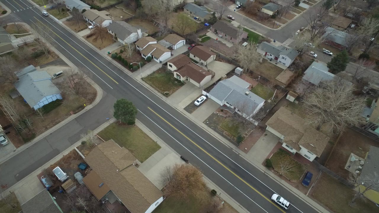 Aerial view of a residential road and surrounding houses.