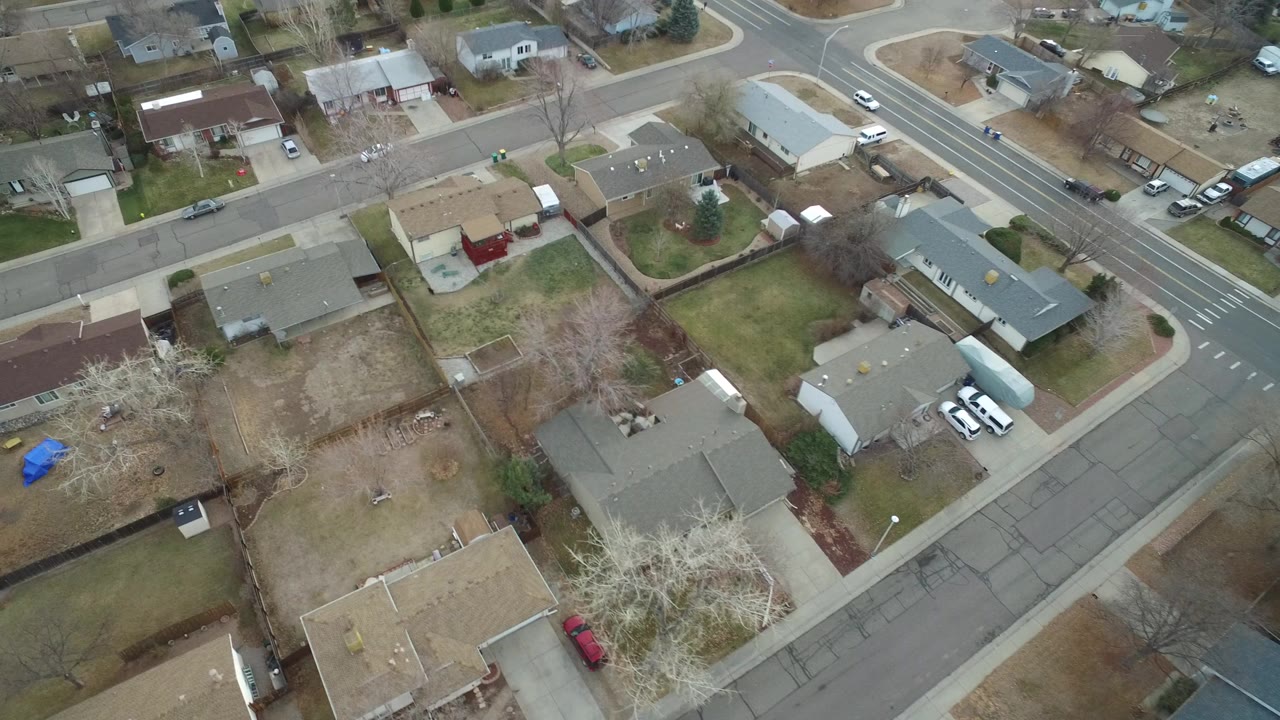 Aerial view of suburban houses, yards, and intersecting streets.