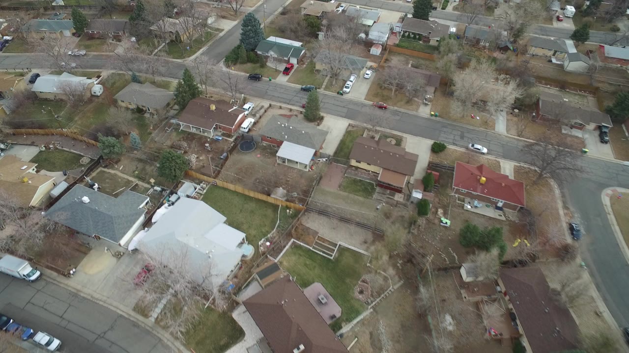 Aerial view of suburban houses, yards, and intersecting streets.