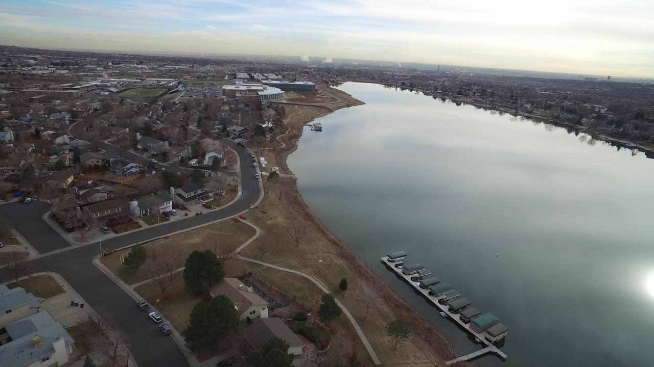 Aerial view of homes beside a reflective lake.