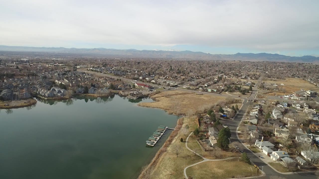 Aerial view of a lake beside residential streets and homes.