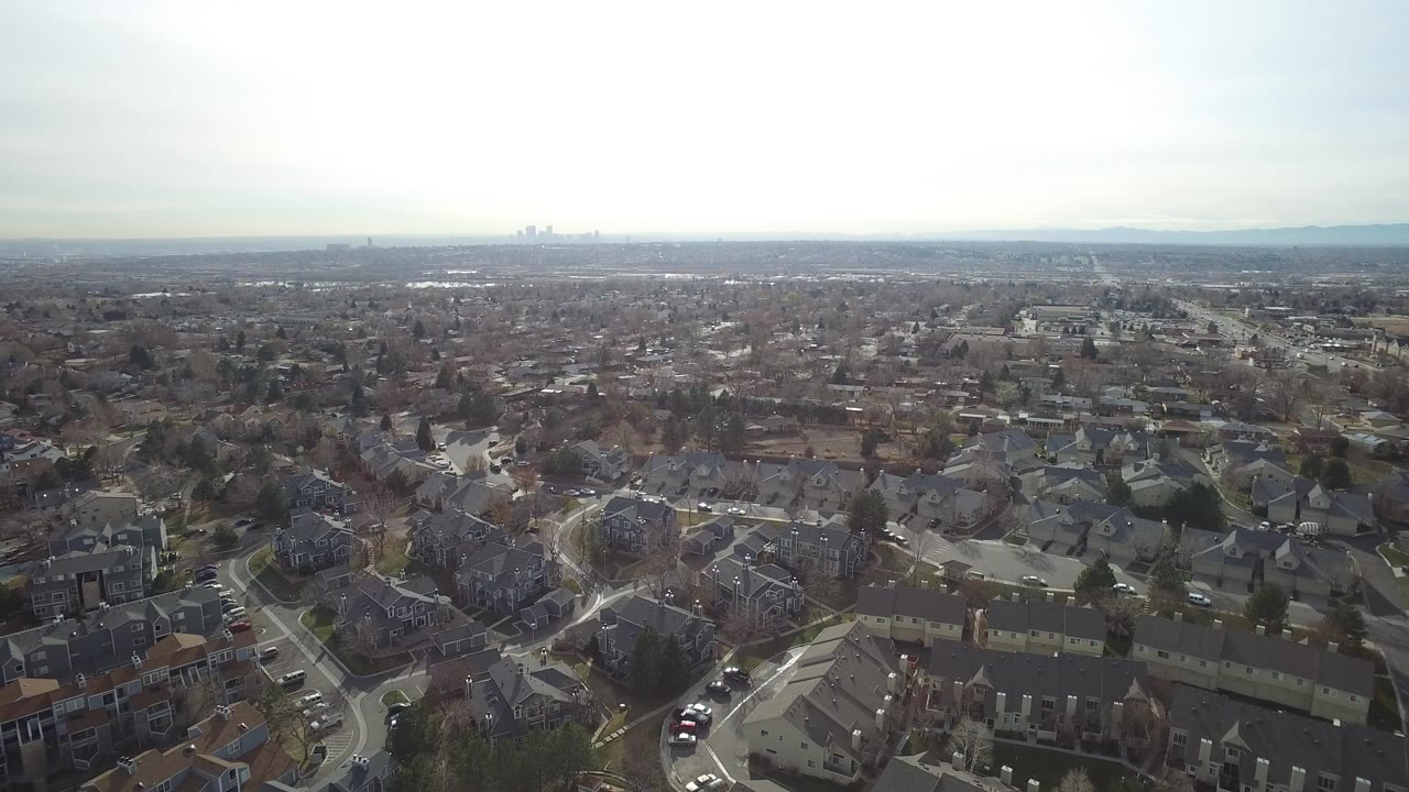 The second frame keeps the Westminster, Colorado neighborhood spread across the foreground, with clustered homes, parked cars, bare trees, distant skyline shapes, and no visible people.