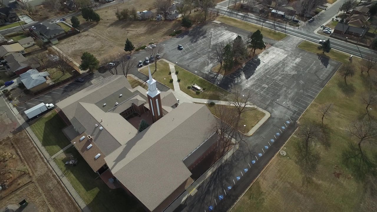 Oblique aerial of a church campus with roads and homes beyond it.