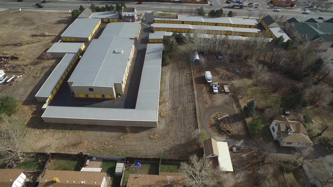 Aerial view of a gray-roofed industrial building beside a road