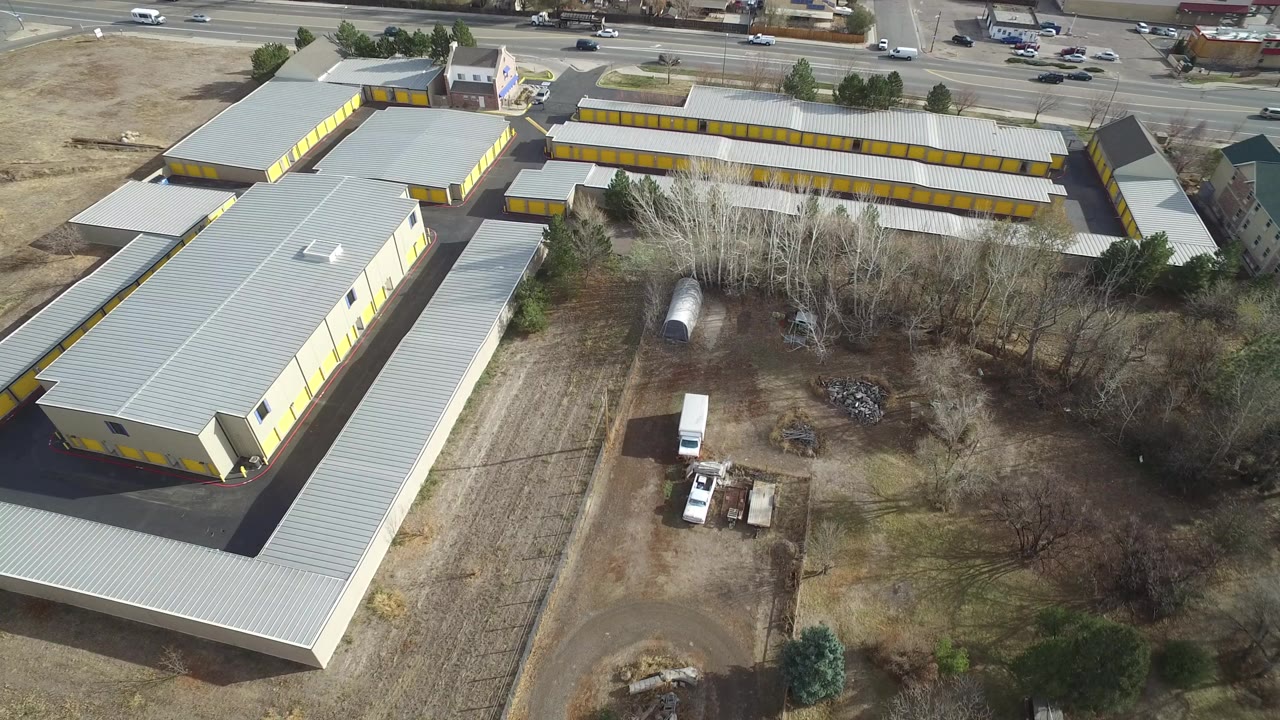 Aerial view of yellow commercial buildings beside a busy road.