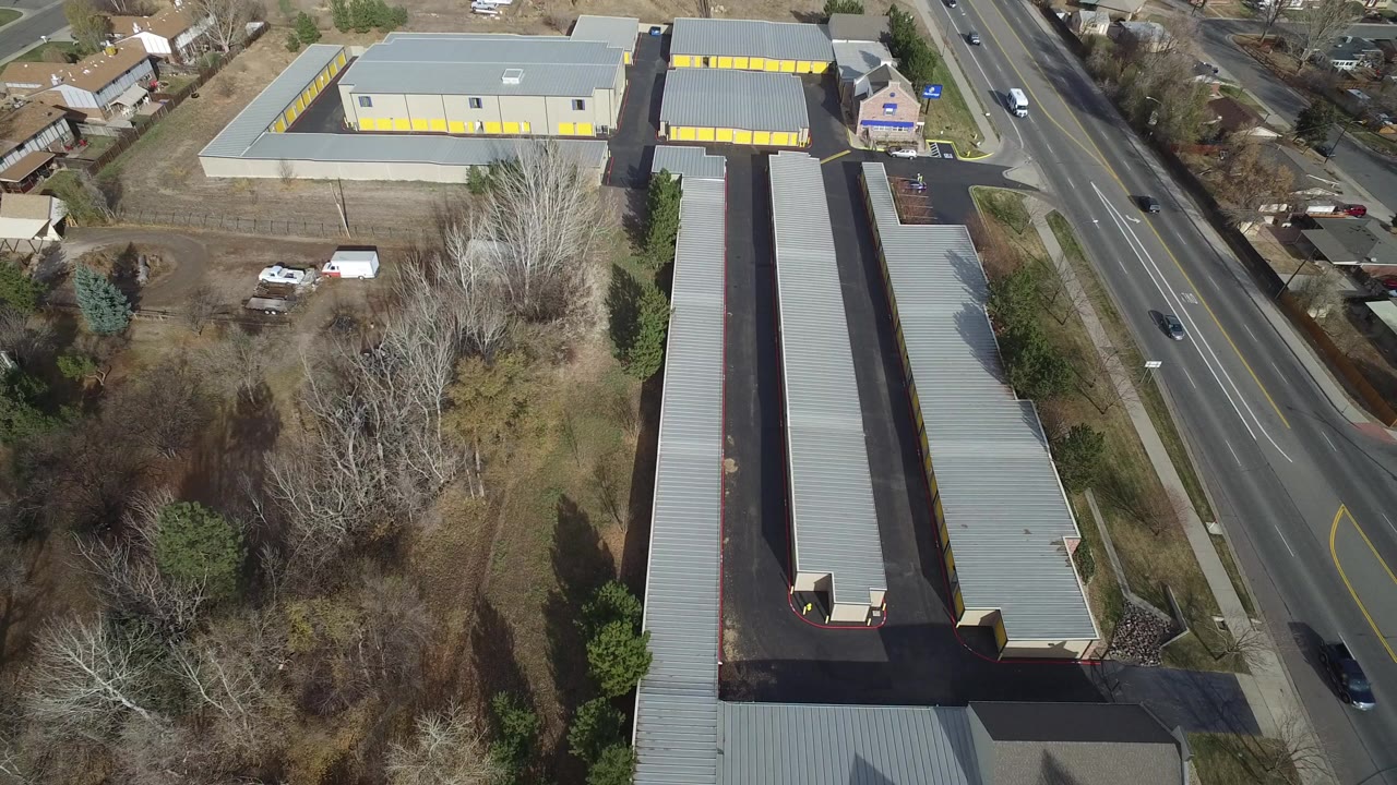 Aerial view of gray storage buildings beside a multi-lane road.
