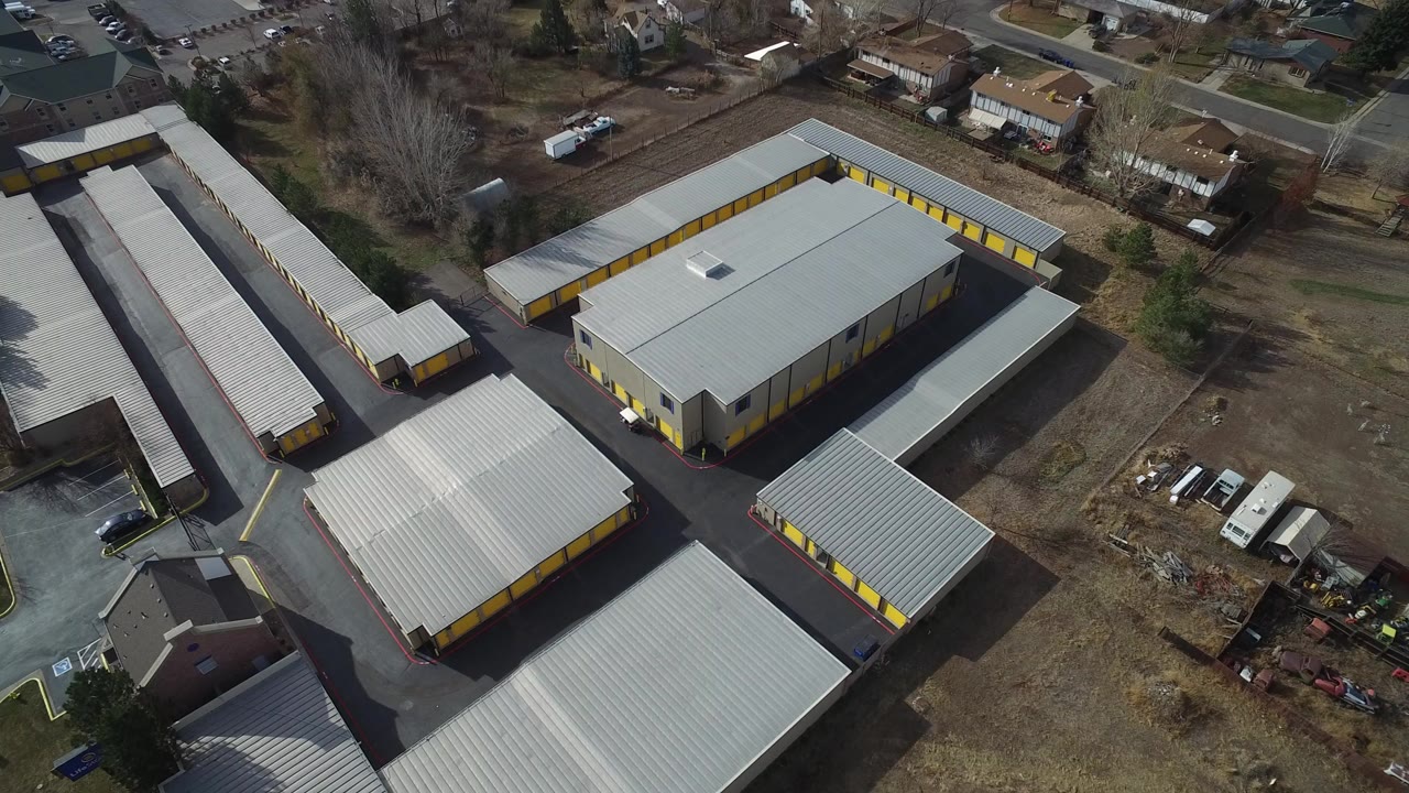 Aerial view of yellow warehouse buildings with metal roofs and paved drives.