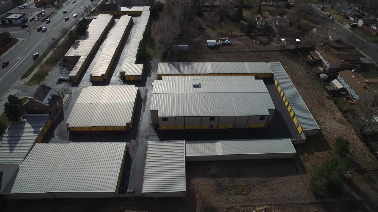 Aerial view of metal-roof industrial buildings beside a road.