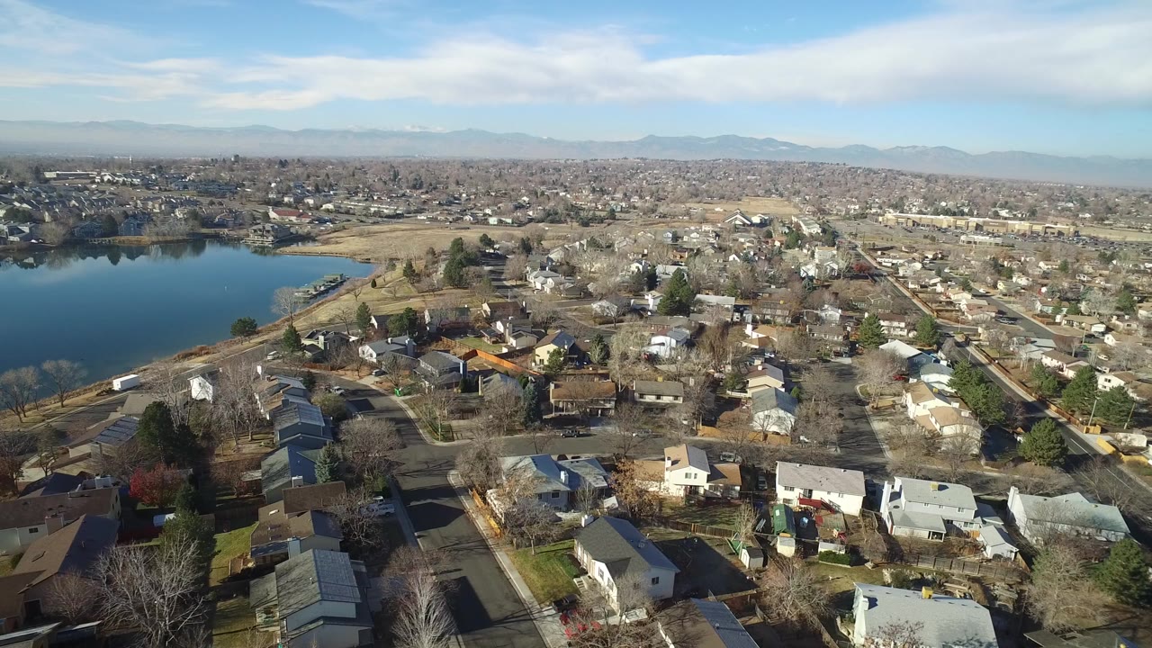 Aerial view of a small lake beside a residential neighborhood.
