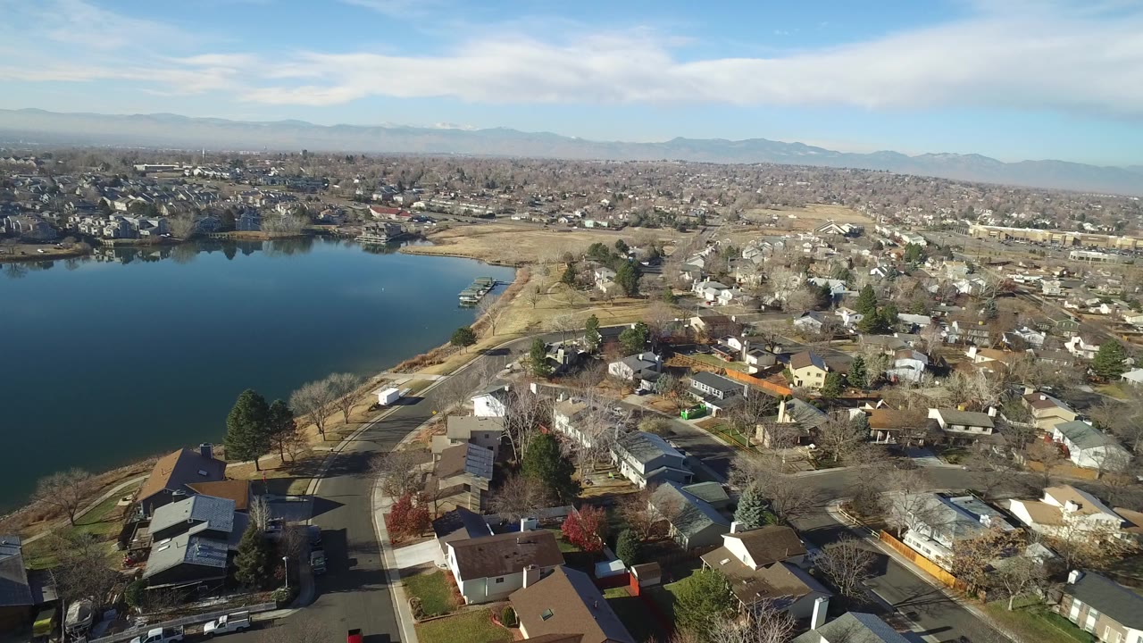 Aerial view of a lake beside suburban houses and streets.