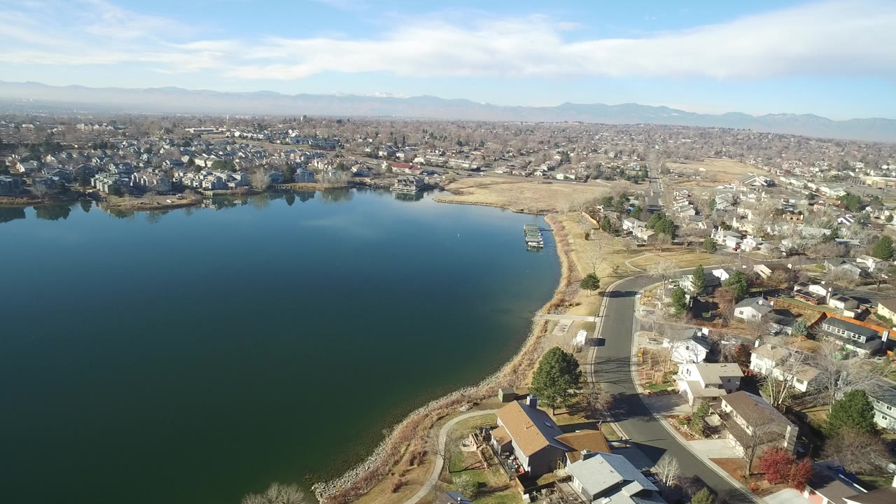 Aerial view of a lake beside residential streets and houses.