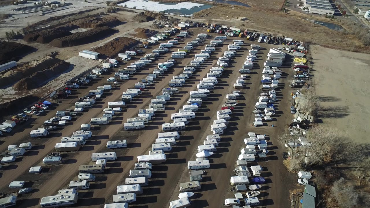 Aerial frame of Hidden Lake, Colorado showing dense rows of RVs and caravans, a bare dirt area to the right, excavation piles at the top, and no clearly visible people.