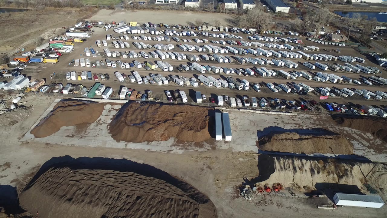 Aerial view of trailer rows beside dirt construction material piles.