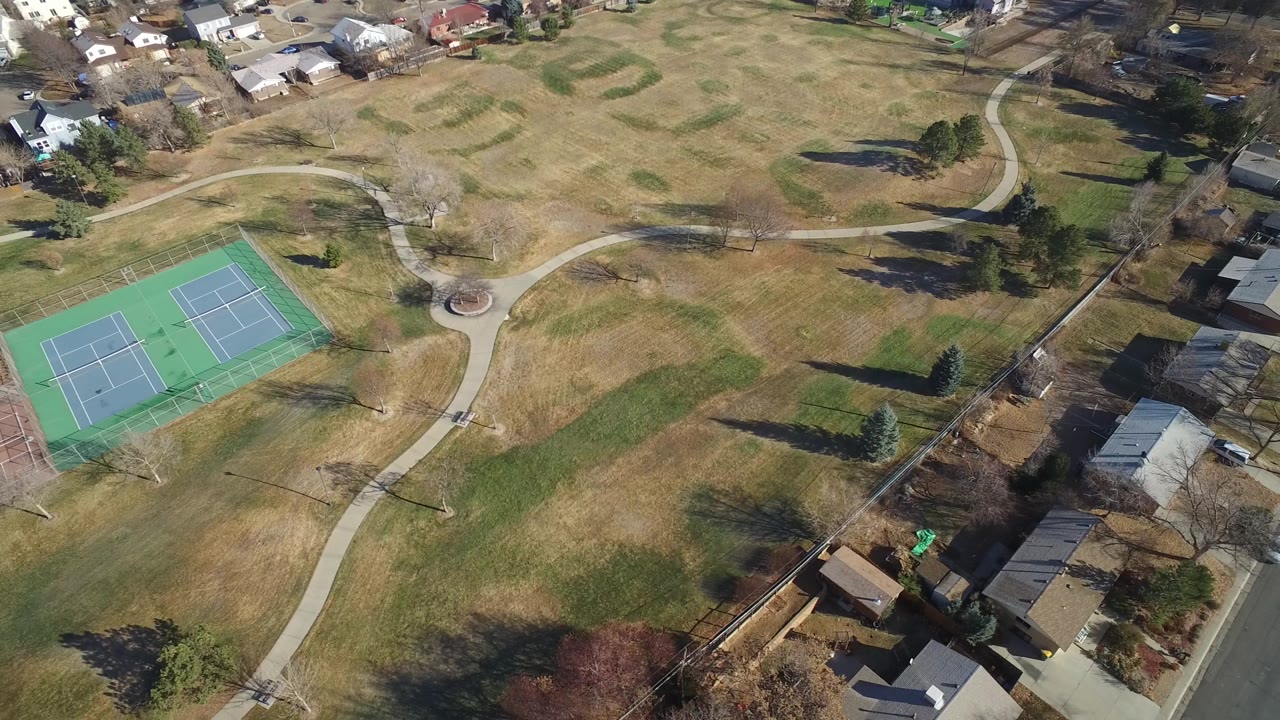 The second frame keeps the Hidden Lake, Colorado tennis courts near the lower left, with pale winter grass, curving footpaths, bare trees, homes, and no visible people.