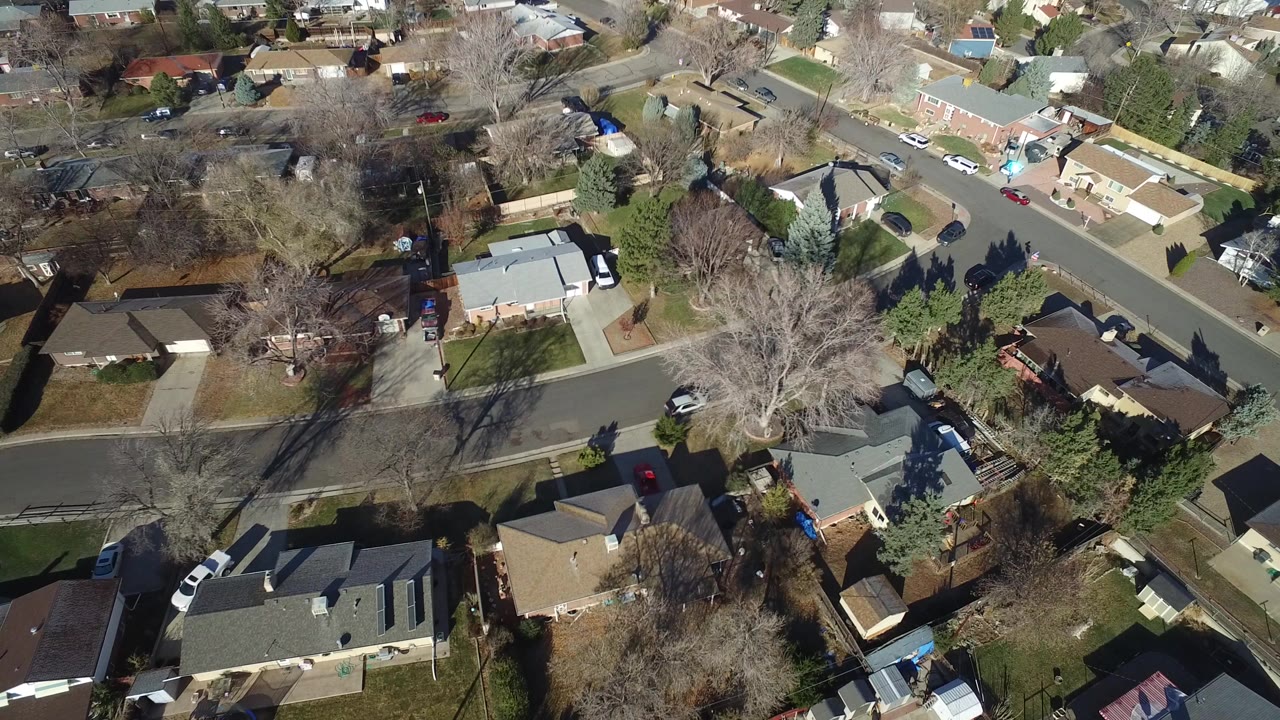 High aerial view of suburban homes and intersecting residential streets.