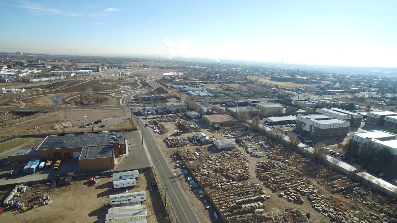 Aerial industrial area with scrapyard, road, and highway ramps