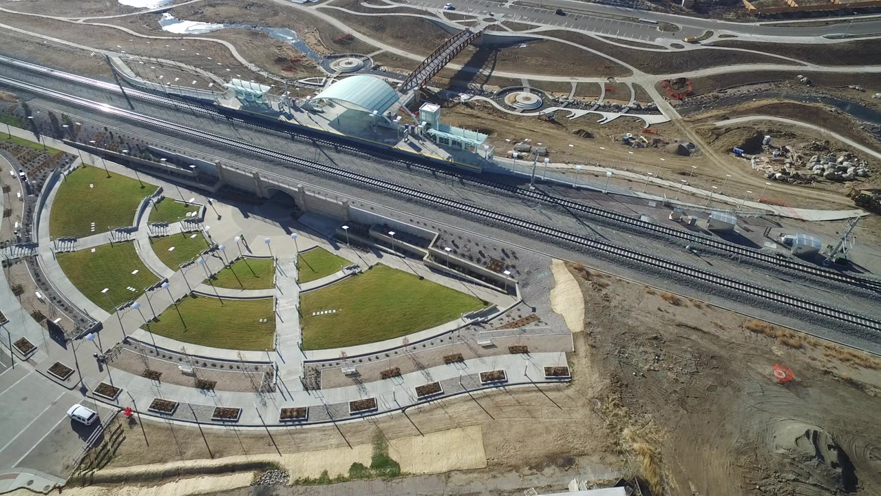 Aerial view of roads, rail tracks, lawns, and construction ground.