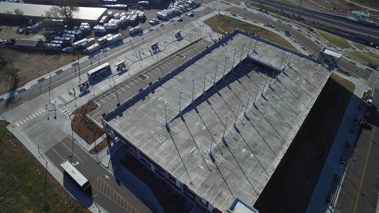 Aerial shot of a mostly empty parking deck next to buses and roads.