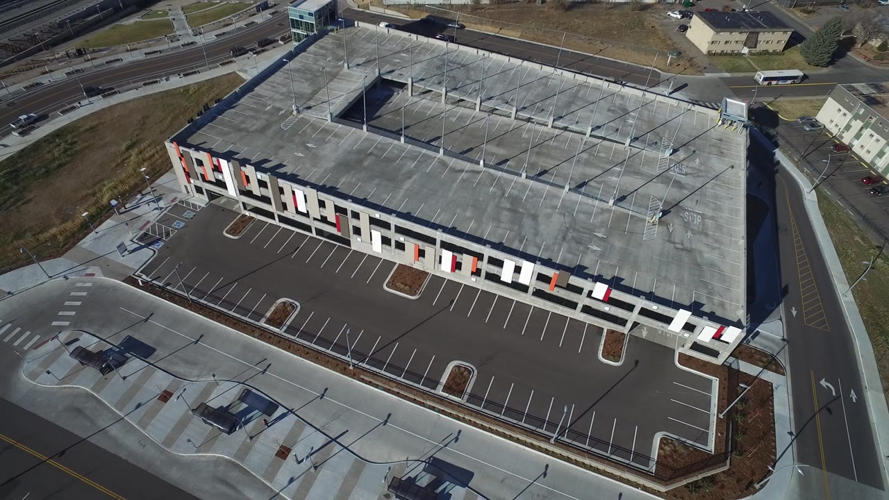 Aerial view of a large modern building and empty parking lot.