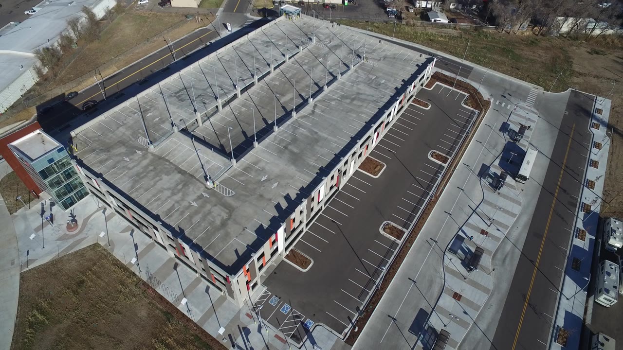High angle view of a commercial-looking building roof beside an empty parking lot.