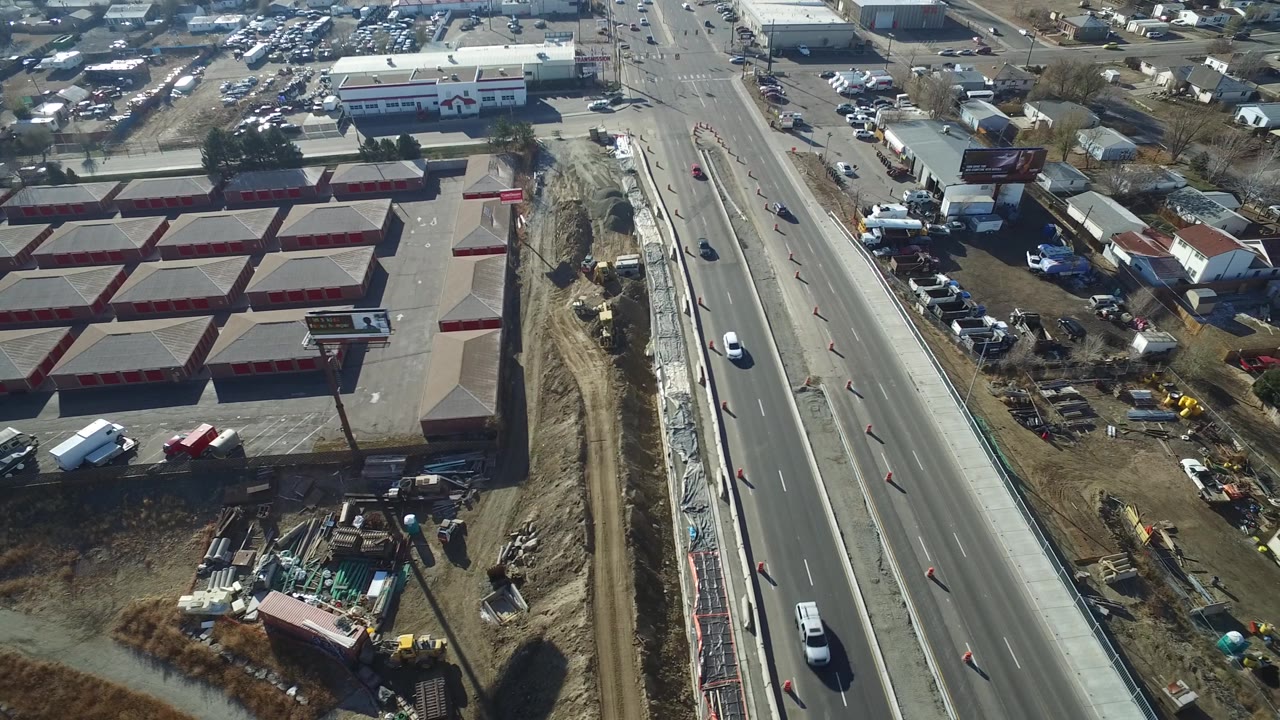 Drone view of a road construction lane with cars and mixed commercial-residential surroundings.
