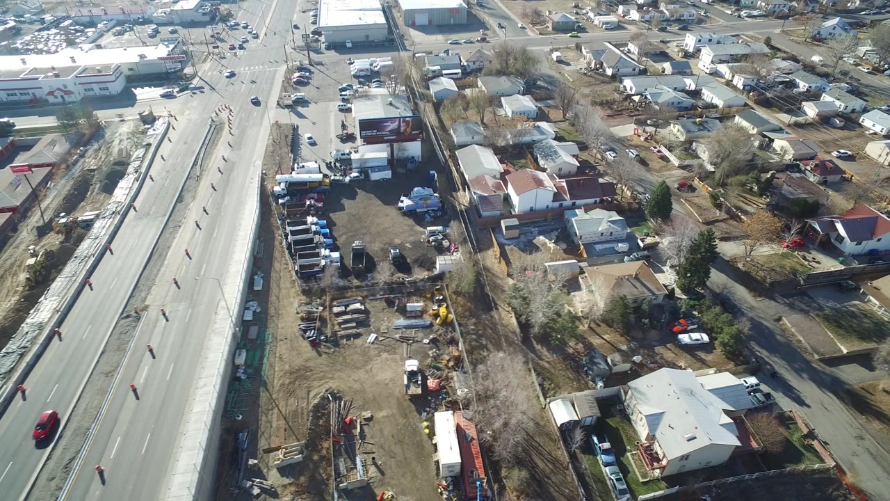 Aerial view of a roadway beside suburban homes and commercial buildings.