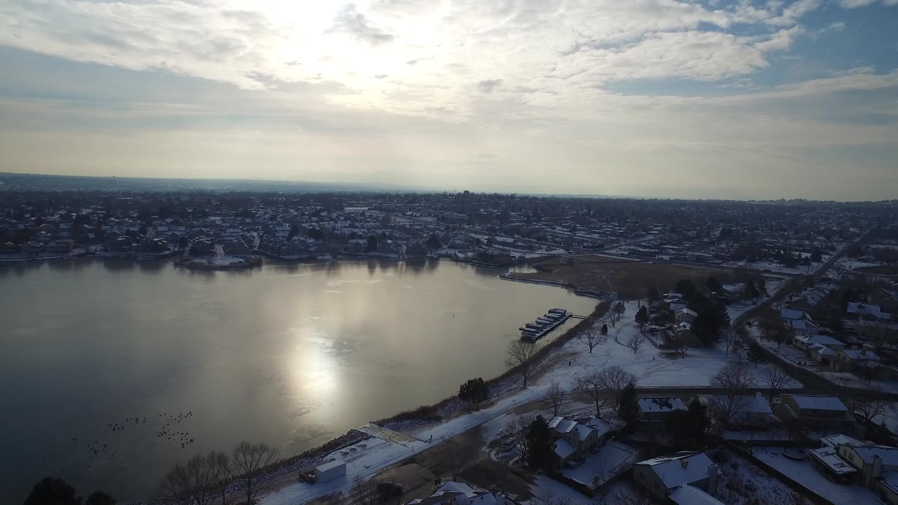 The second frame holds a wide Hidden Lake Colorado view with reflective water at left, snowy ground near the shore, private homes, roads, and no visible people.