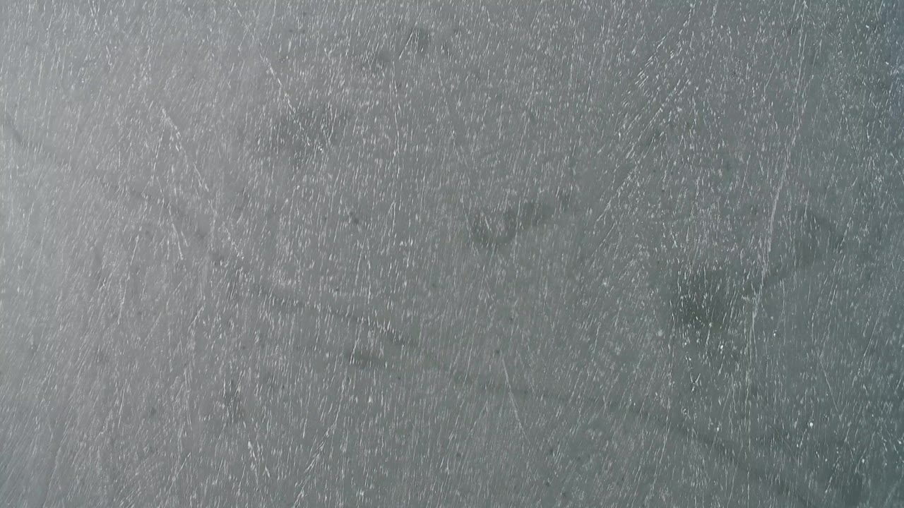 Top-down view of a blue-gray lake surface at Hidden Lake, Colorado, with pale streaked texture and no visible people.