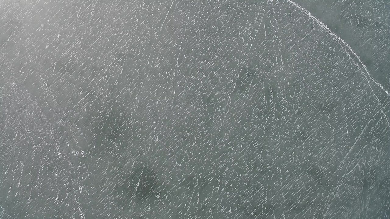 Overhead blue-gray textured surface with pale curved lines.