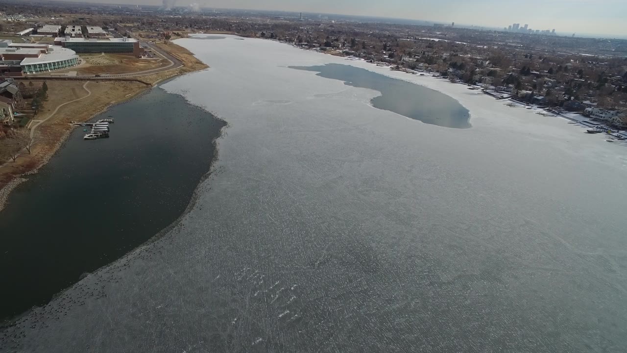Oblique aerial of ice-covered water and residential shoreline
